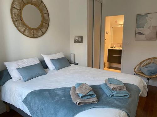 sypialnia z dużym łóżkiem z ręcznikami w obiekcie La Petite Chouette, charmant et cosy T2 w mieście Dijon