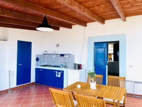 cocina con armarios azules y mesa de madera en Villa Margherita - Appartamenti a due passi dal corso di Santa Marina Salina a 100 mt dalla spiaggia, en Santa Marina Salina