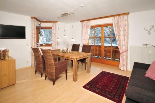- un salon avec une table et des chaises en bois dans l'établissement Ferienwohnung Bär, à Reit im Winkl