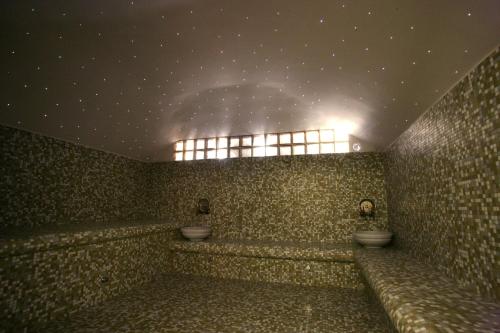 Baño con 2 aseos en una pared de azulejos en Long View Hammam & Spa, en Porto Heli