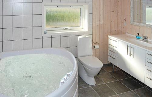 a bathroom with a tub and a toilet and a sink at Beautiful Home In Nordborg With 3 Bedrooms, Sauna And Wifi in Nordborg