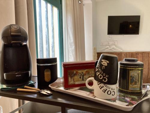 - un plateau avec des tasses à café et une cafetière sur une table dans l'établissement Studio Le City - Petit déjeuner inclus 1ère nuit - AUX 4 LOGIS, à Foix