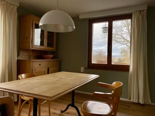 eine Küche mit einem Tisch und Stühlen sowie einem Fenster in der Unterkunft Gemütliches Haus mit Seeblick in Ermatingen