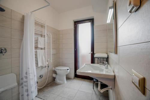 a white bathroom with a toilet and a sink at SIGIS HOTEL - Fiumicino in Fiumicino