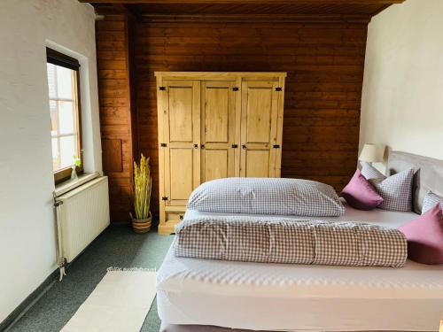a bedroom with a bed and a wooden wall at Hotel zum Urviech -Erwachsenenhotel- in Ehrwald