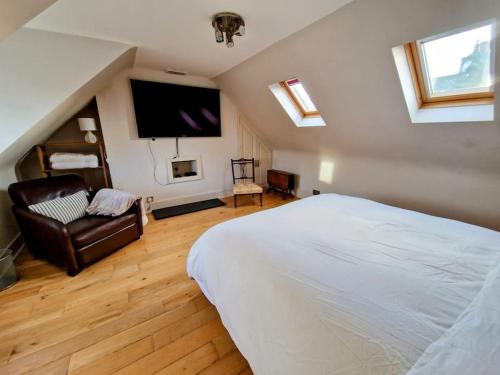 um quarto com uma cama, um sofá e uma televisão em Welcome to Fittie, on the beach! em Aberdeen