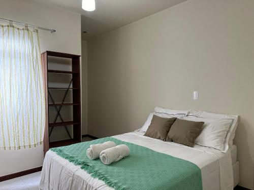 - une chambre avec un lit et des serviettes dans l'établissement Apto 2Q completo em frente a praia Ponta da Fruta, à Ponta da Fruta
