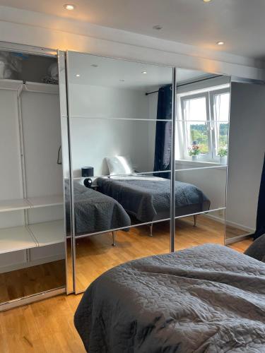 a bedroom with two beds and a mirror at Fin uthyrningsdel med egen terass in Kungsängen