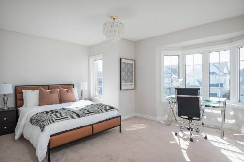 a bedroom with a bed and a desk and a chair at The Bliss in Bowmanville