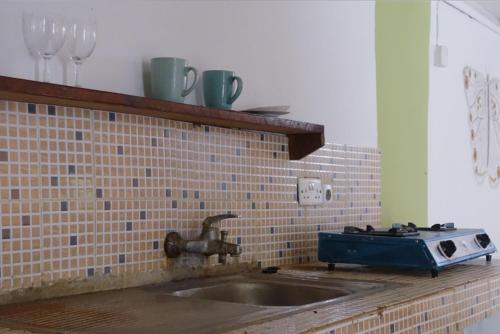 a kitchen counter with a sink and a stove at Diani Peaceful Garden in Diani Beach