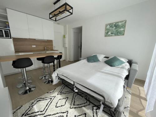 un lit d'hôpital dans une pièce avec une table et des chaises dans l'établissement T2 Nature & Coworking, à Morsang-sur-Orge