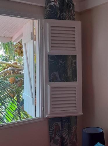 a white cabinet with a window in a room at Villahaut in Le Robert