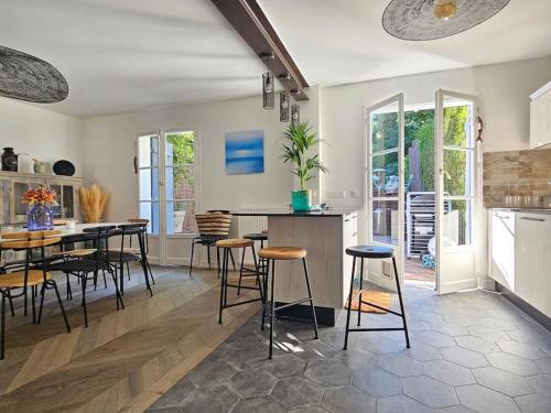 une cuisine avec une table et des tabourets dans une pièce dans l'établissement Maison familiale 12 couchages, spa et terrasse, à Deauville