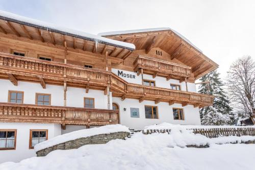 Un gran edificio con nieve delante. en Schwüwong - Apartment 11, en Kelchsau