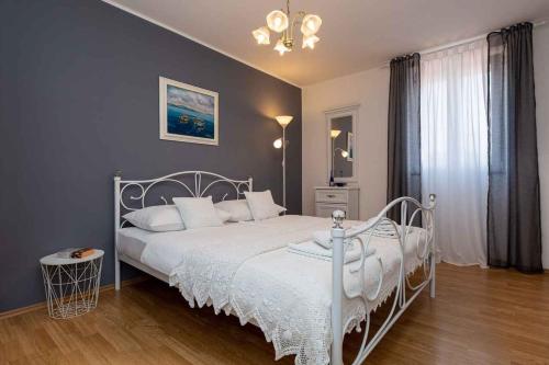 a bedroom with a white bed and a chandelier at Apartment in Vrbnik - Insel Krk 45252 in Vrbnik