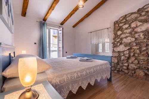 ein Schlafzimmer mit einem Bett und einer Steinwand in der Unterkunft Holiday home in Vrbnik - Insel Krk 47398 in Vrbnik