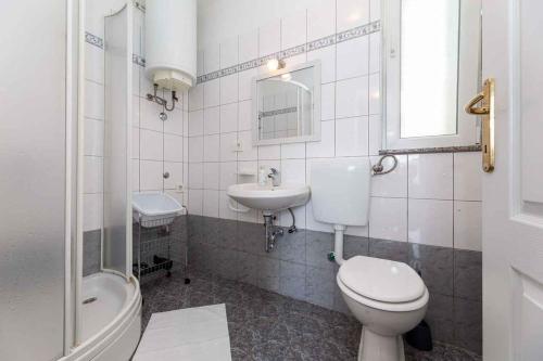 a white bathroom with a toilet and a sink at Apartment in Vrbnik - Insel Krk 45252 in Vrbnik