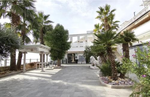 a courtyard with palm trees in front of a building at Villa Eidos b&b in Domicella