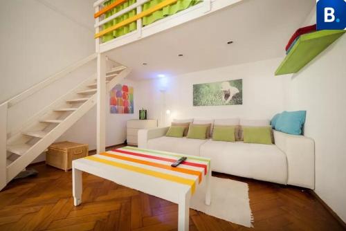 a white living room with a white couch and stairs at Jókai Apartment in Budapest
