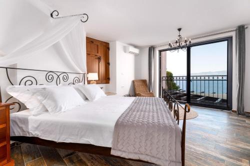 a bedroom with a white bed and a balcony at Holiday home in Vrbnik - Insel Krk 45251 in Vrbnik