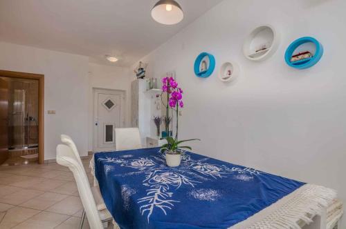 ein Esszimmer mit einem blauen und weißen Tisch mit einer Pflanze darauf in der Unterkunft Apartment in Vrbnik - Insel Krk 47401 in Vrbnik