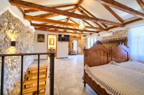 ヴルブニクにあるHoliday home in Vrbnik - Insel Krk 45249のベッドと石の壁のある寝室