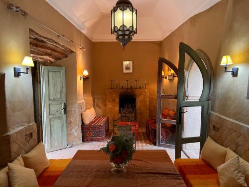 a living room with a fireplace and a chandelier at Dar Les Dattiers in Taroudant