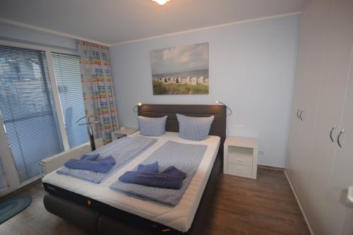 ein Schlafzimmer mit einem Bett mit blauen Kissen darauf in der Unterkunft Likedeeler Whg. 7 in Boltenhagen