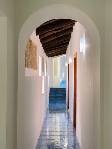 a hallway with an archway and stairs in a house at La Locanda del Curato Rooms in Lentiscosa