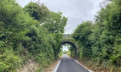 an empty road with an arch in the middle at County Hideaway in Limerick