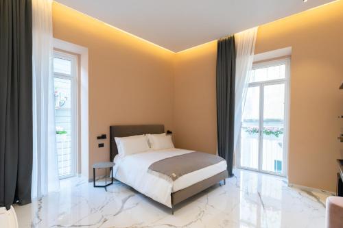 a bedroom with a bed and two windows at InSogno Suites in Naples