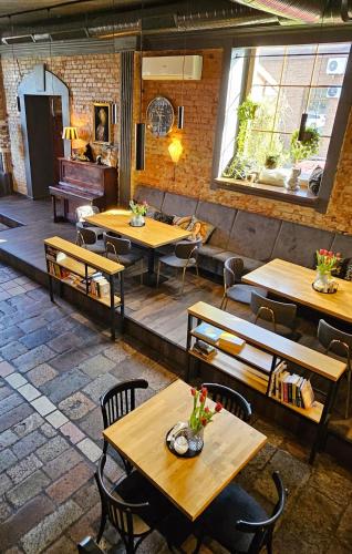a restaurant with wooden tables and chairs and a piano at Pensjonat Retro in Łomża