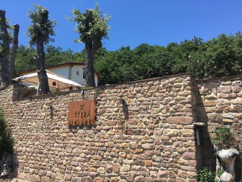 Una pared de piedra con un cartel. en Villa Liguardi, en Proaño