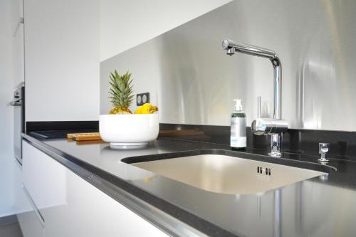 a kitchen sink with a faucet on a counter at Tropic & Chic in Sainte-Anne