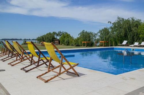 uma fila de cadeiras sentadas ao lado de uma piscina em Aguas del Monte Hotel SPA em San Miguel del Monte