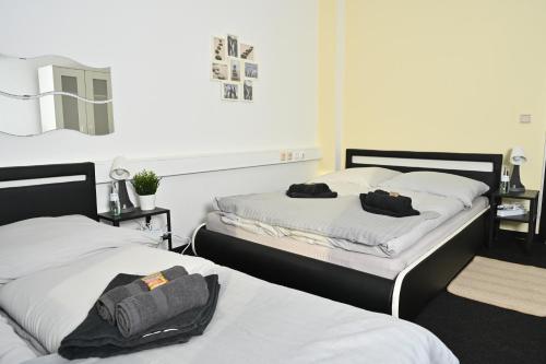 two beds in a room with white sheets at Pott Hostel - Zimmervermietung in Essen