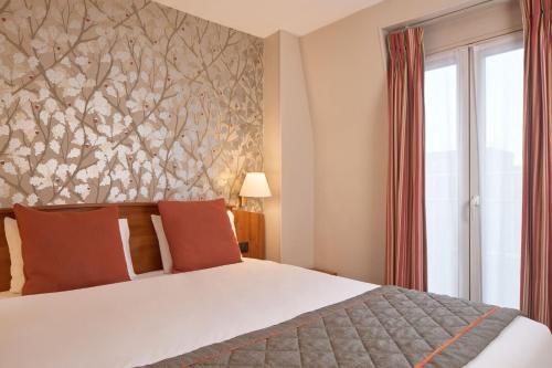 Una cama o camas en una habitación de Timhotel Paris Gare Montparnasse