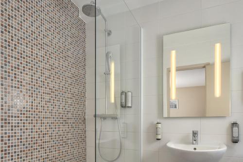 a bathroom with a shower and a sink and a mirror at Timhotel Paris Gare Montparnasse in Paris