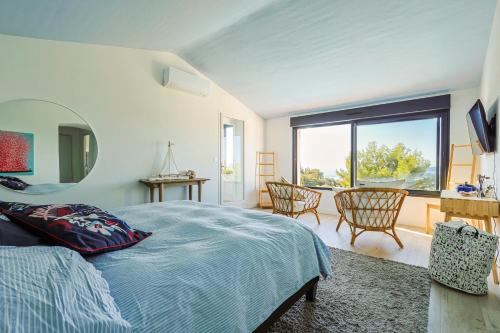 une chambre avec un lit et une grande fenêtre dans l'établissement Villa d'exception avec très belle vue mer - Villa Joyce, à Sainte-Maxime