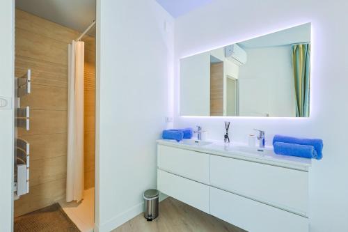 une salle de bain avec un lavabo blanc et un miroir dans l'établissement Villa d'exception avec très belle vue mer - Villa Joyce, à Sainte-Maxime