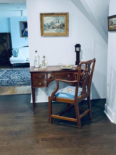 a desk with a chair and a table with a picture at 1000 Islands Bed and Breakfast-The Bulloch House in Gananoque