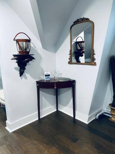 a table with a mirror and glasses on a wall at 1000 Islands Bed and Breakfast-The Bulloch House in Gananoque