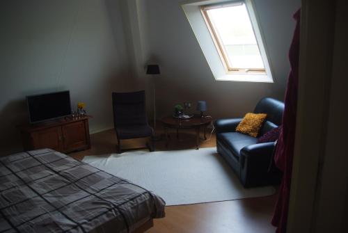 a living room with a couch and a bed and a window at B&B Noflik Haule in Haule