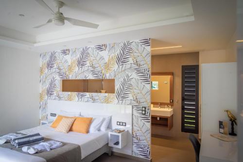 1 dormitorio con 1 cama grande y pared en Tropic & Chic, en Sainte-Anne