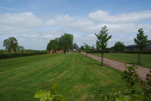 a large grass field with a house in the background at B&B Noflik Haule in Haule