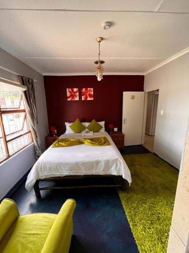1 dormitorio con 1 cama blanca grande y paredes rojas en E.G Guest House, en Kokstad