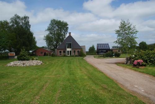 a house with a dirt road in front of a field at B&B Noflik Haule in Haule