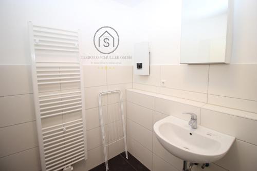 a white bathroom with a sink and a mirror at Exklusive Monteurs-Wohnung in Radevormwald