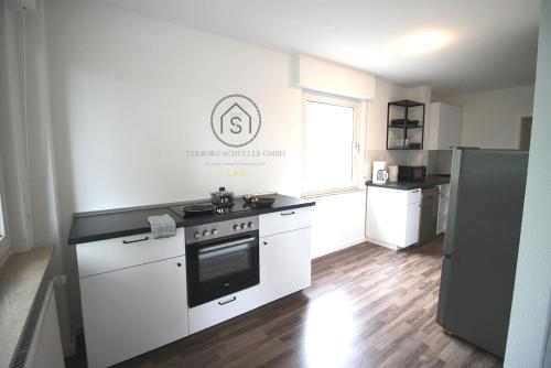 a white kitchen with a stove and a window at Exklusive Monteurs-Wohnung in Radevormwald