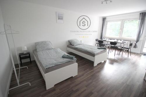 a bedroom with two beds and a dining table at Exklusive Monteurs-Wohnung in Radevormwald